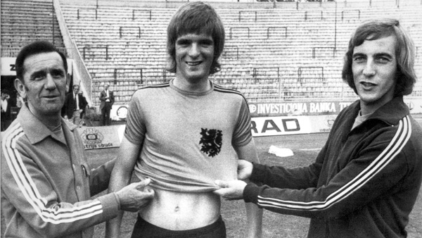Heini Otto wordt in het Oranjeshirt gehesen door bondscoach George Knobel en Johan Neeskens.